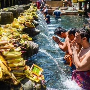 Wisatawan berfoto dengan latar belakang pemandangan Pura Tanah Lot saat sore hari.
