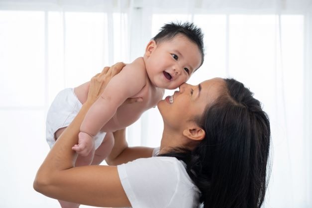Seorang ibu sedang menggendong anaknya