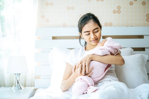 Seorang ibu sedang menggendong anaknya