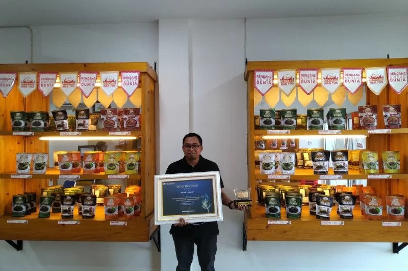 Owner Rendang Mak Yus Wahyu Hidayat  saat menunjukan plakat  penghargaan dari Bank Indonesia Sumatera Barat sebagai produk UMKM dengan teknik pemasaran terbaik tahun 2021.